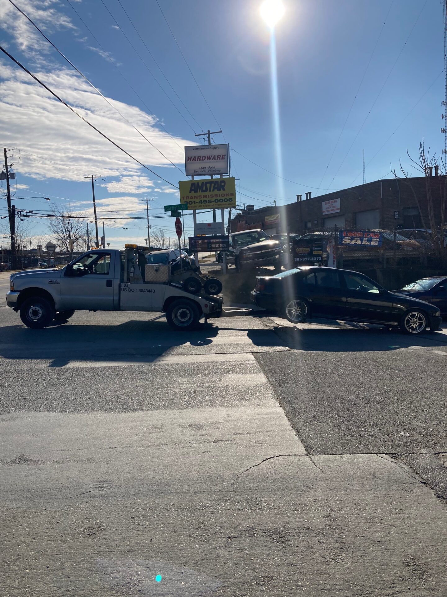 A tow truck located in a parking lot, available for towing and roadside support.