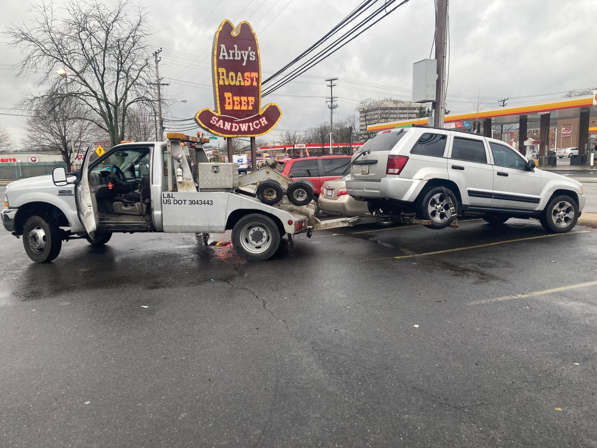 A tow truck is parked outside a restaurant, ready to assist with vehicle removal or roadside service