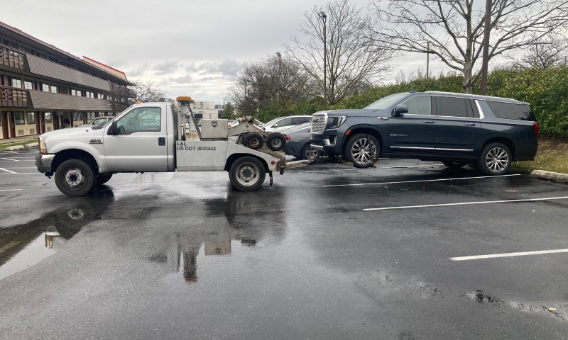 A tow truck parked in a parking lot, ready to assist vehicles in need of towing services